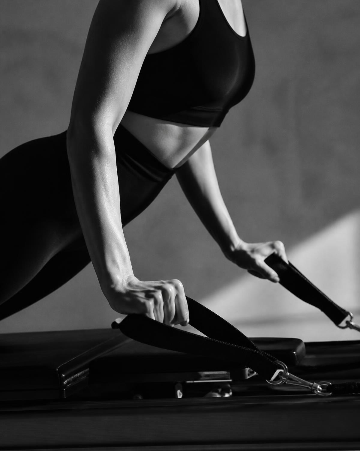 Detail of a controlled Pilates movement on a reformer